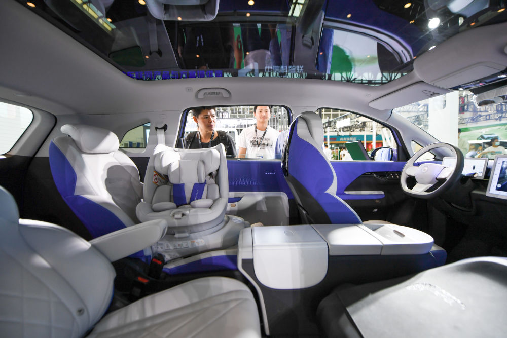 9月21日，在2023世界智能网联汽车大会室内展区，几位参观者在参观一辆新能源汽车。新华社记者 鞠焕宗 摄